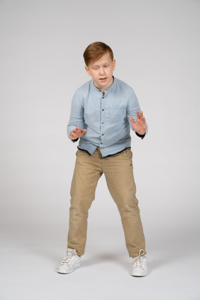 Young boy in blue shirt and khaki pants gesturing