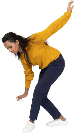 Side view of a girl in casual clothes bending down with outstretched arms