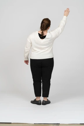 Rear view of a plump woman in casual clothes greeting someone