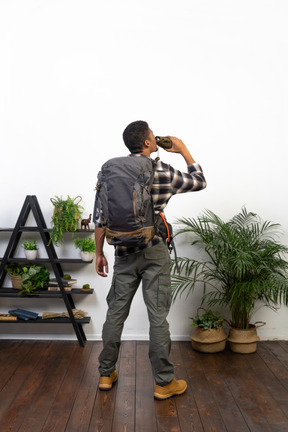 Back view of a tourist drinking from a flask