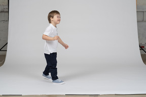 Vista lateral del niño alegre caminando