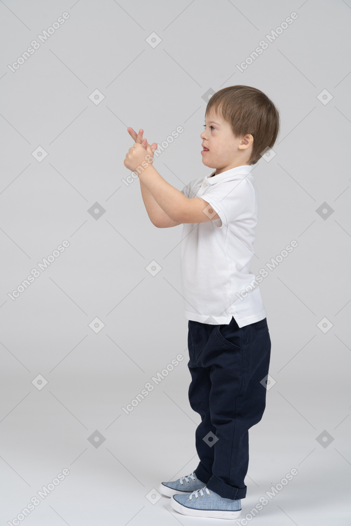 Kleiner junge hält seine hände hoch