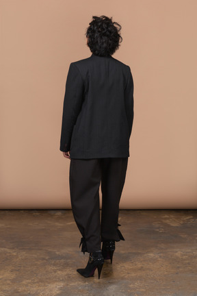 Vista traseira de uma mulher irreconhecível vestindo terno preto