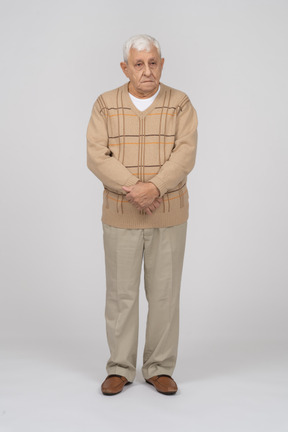 Front view of an old man in casual clothes looking at camera