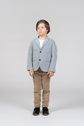 A young boy in a gray jacket and khaki pants