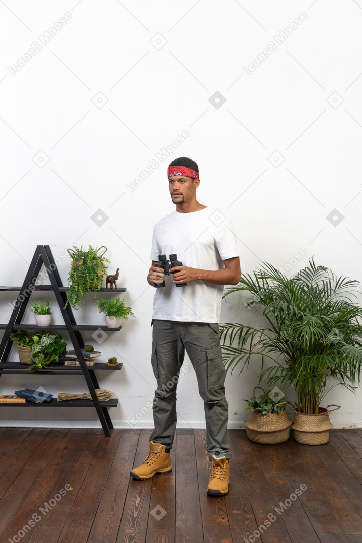Good looking young man holding binoculars