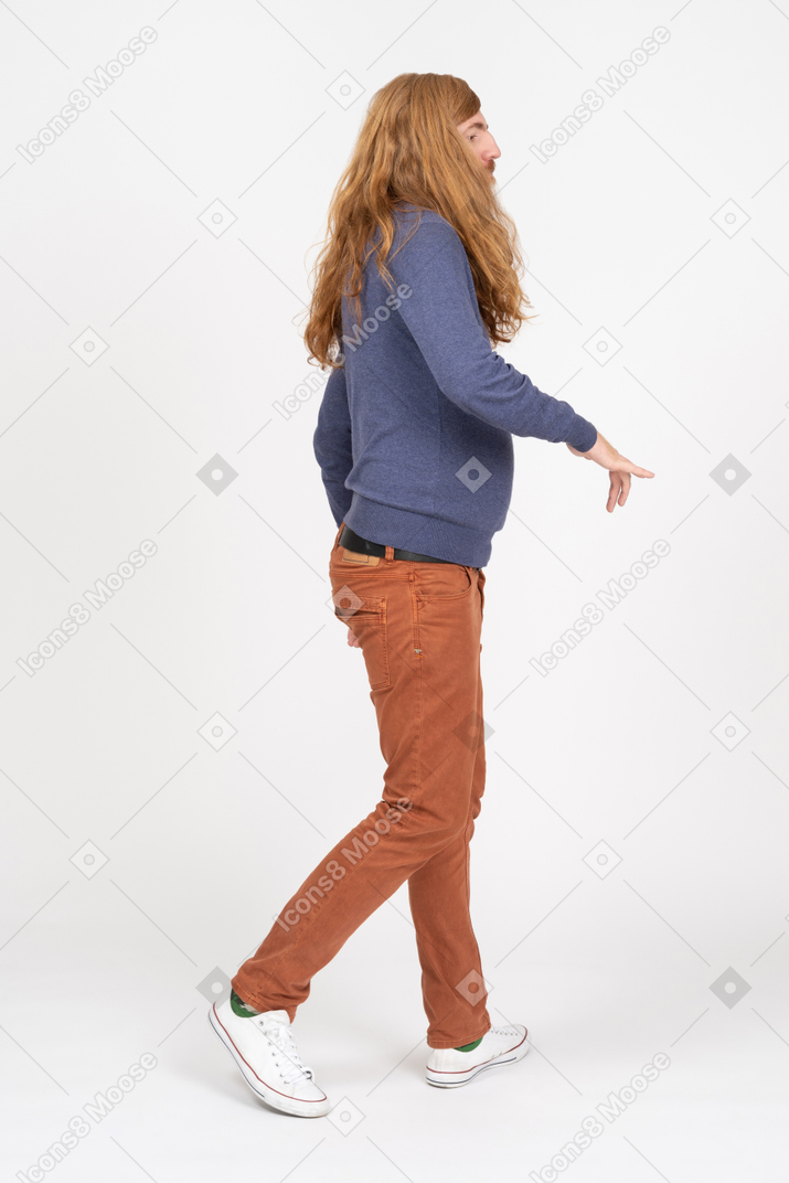 Side view of a young man in casual clothes walking