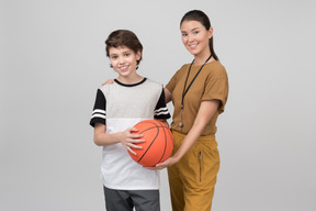 Pe lehrer und schüler, die basketballball halten