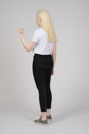 Back view of a young girl standing with her hand in fist