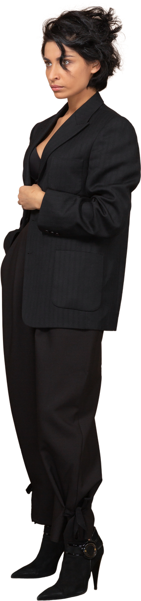 Three-quarter view of a businesswoman dressed in black suit looking seriously aside