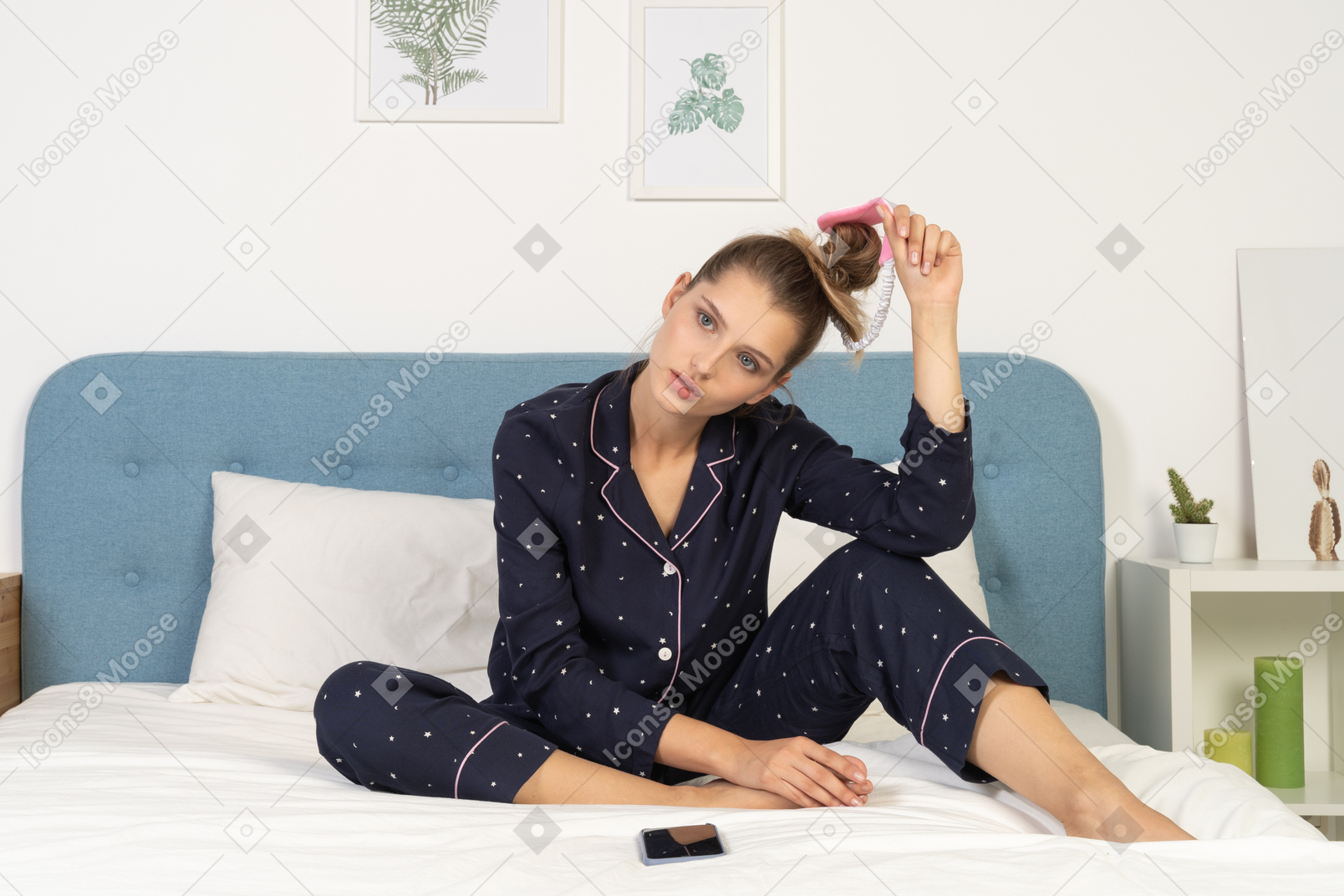 Front view of a young lady in pajamas sitting on bed