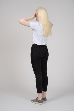 Back view of a blonde woman touching her temples