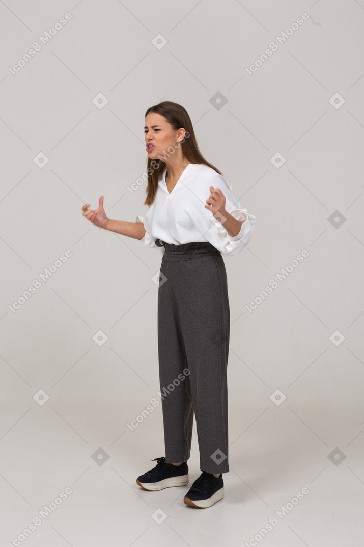 Vue de trois quarts d'une jeune femme gesticulante qui pleure en tenue de bureau