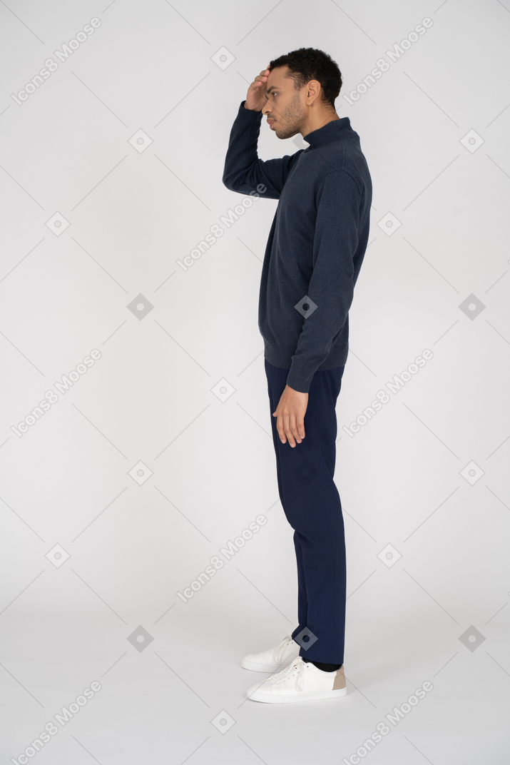 Homem em roupas casuais em pé com a mão na testa