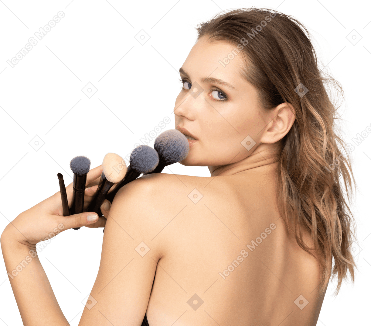Back view of a sensual young woman holding make-up brushes