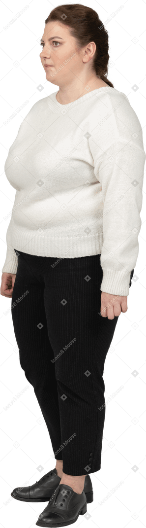 Confident plus size woman in white sweater standing in profile