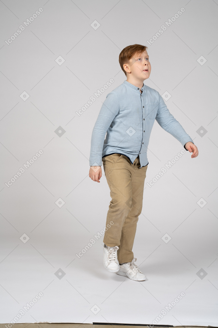 Un ragazzo in piedi davanti a un muro con un libro