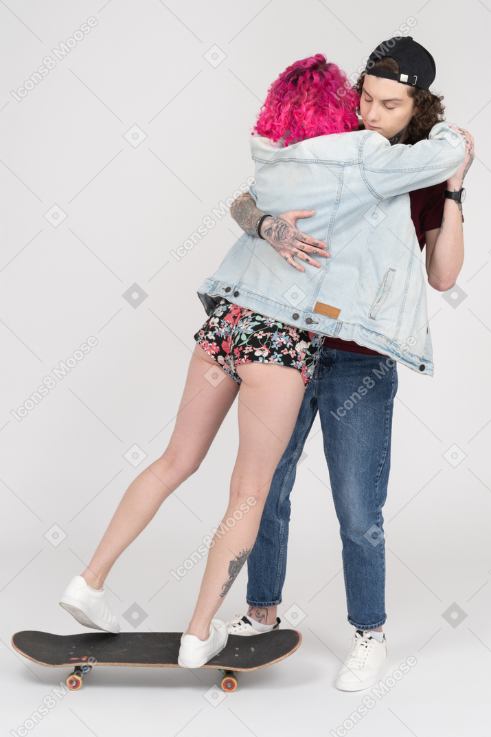Pink haired girl falling down from a skateboard to her boyfriend`s arms