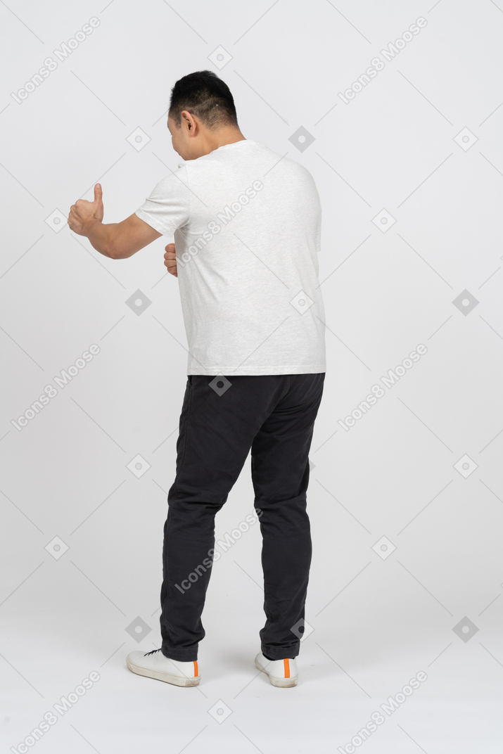 Back view of a man in casual clothes showing thumb up