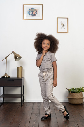 Good looking girl kid posing on the apartment background