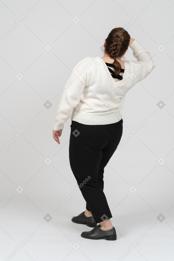 Vista posteriore di una donna grassoccia in abiti casual in cerca di qualcuno