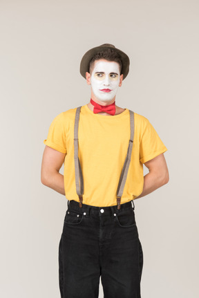 Male clown standing with his hands behind his back