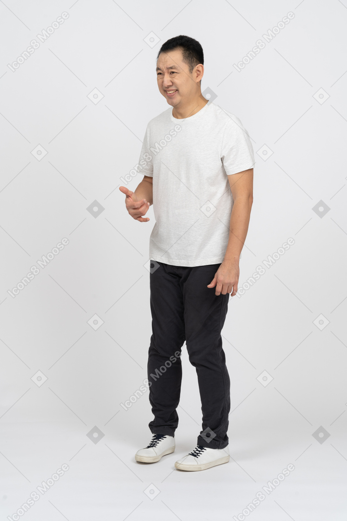 Happy man in casual clothes doing phone gesture