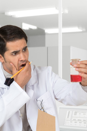 A man in a lab coat holding a test tube