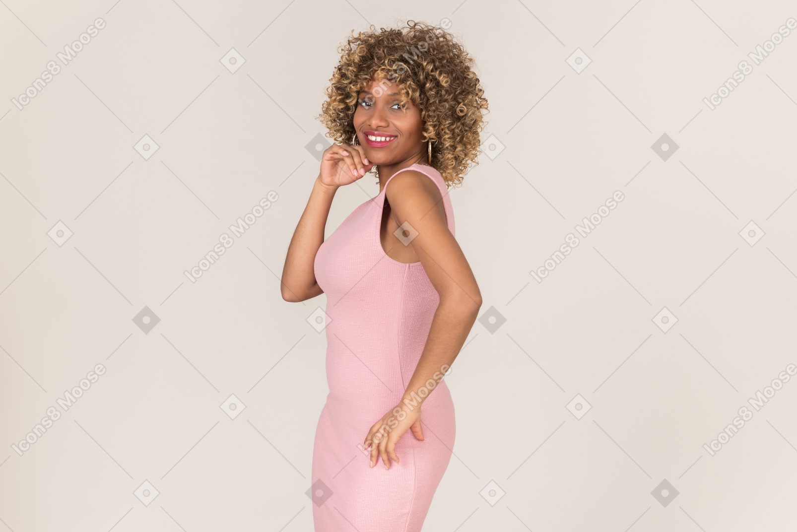 Женщина в розовом платье позирует фотографу