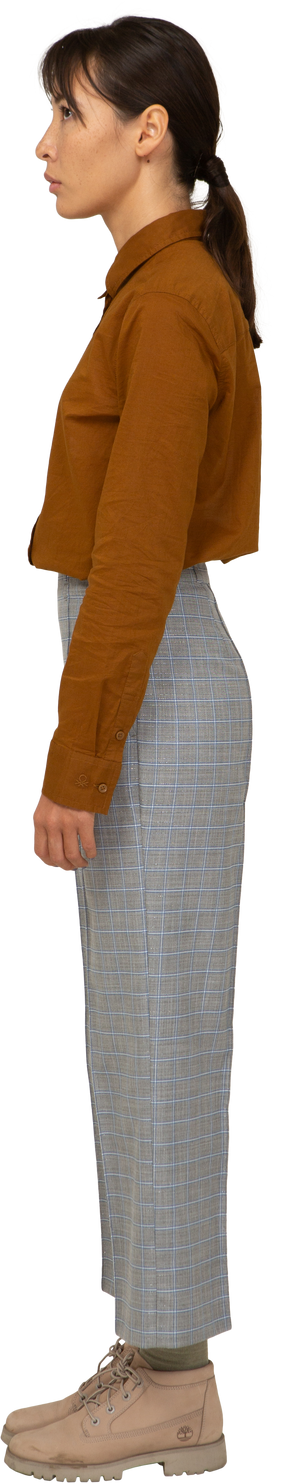 Vista lateral de una joven mujer asiática en calzones y blusa inmóvil
