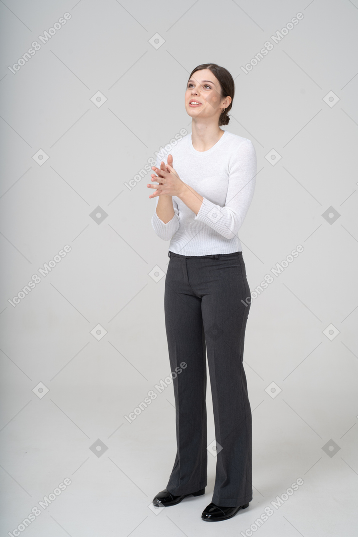 Vista frontale di una donna in giacca e cravatta che guarda in alto e gesticola