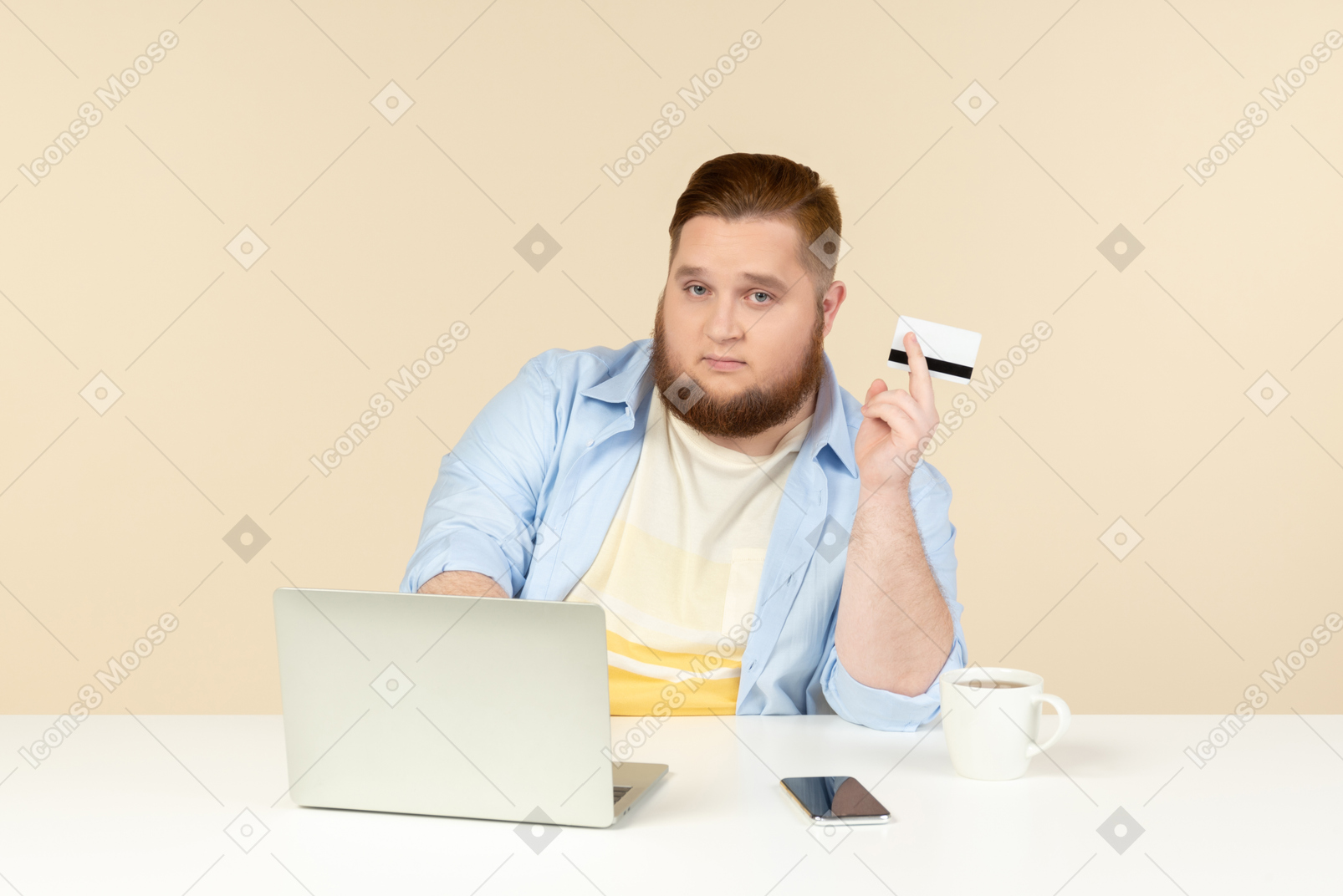年轻的超重男子坐在笔记本电脑和持有银行卡