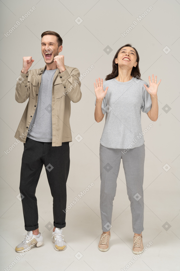 Joyful young couple cheering