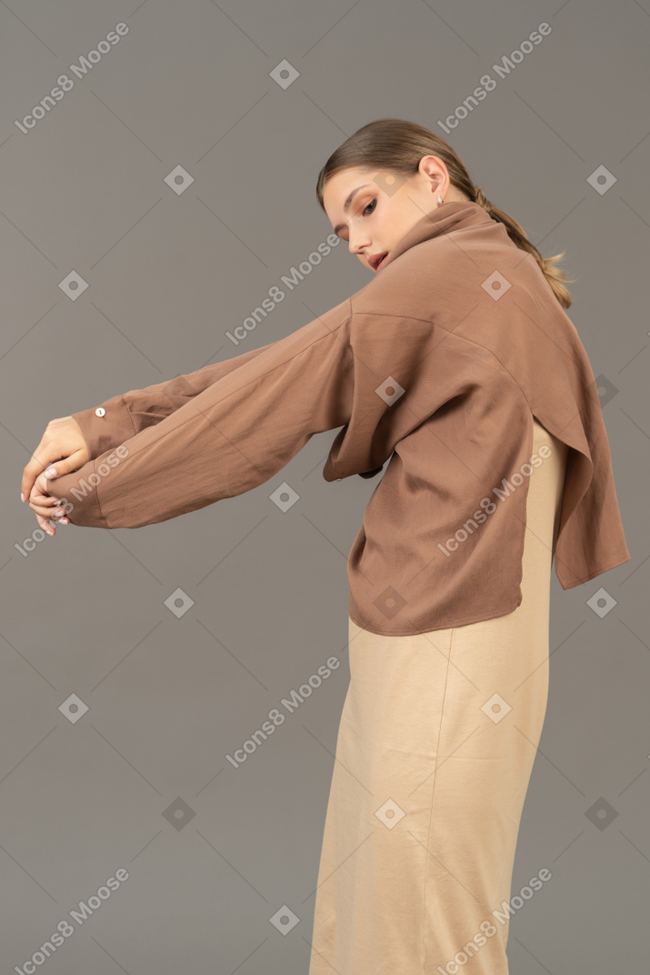 Young woman pulling her sleeve off her arm