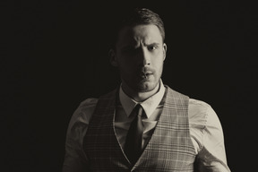 Portrait of a handsome man from 20s isolated over black background