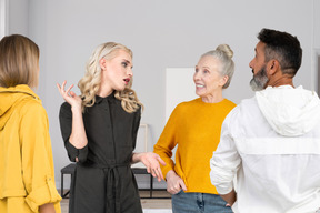 Companhia de amigos interraciais de diferentes idades falando