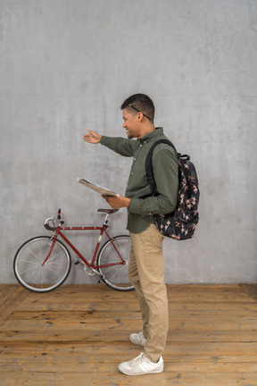 Vista lateral de um homem com uma mochila e um mapa mostrando as direções