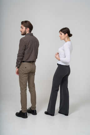 Vista posterior de tres cuartos de una pareja joven en ropa de oficina