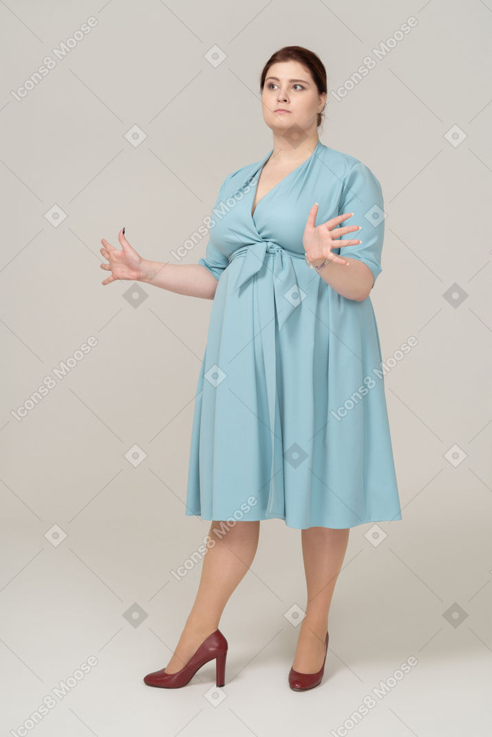 Vista lateral, de, un, mujer, en, vestido azul, posición, con, brazos abiertos