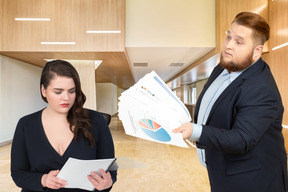 A man showing papers with graphs to a woman