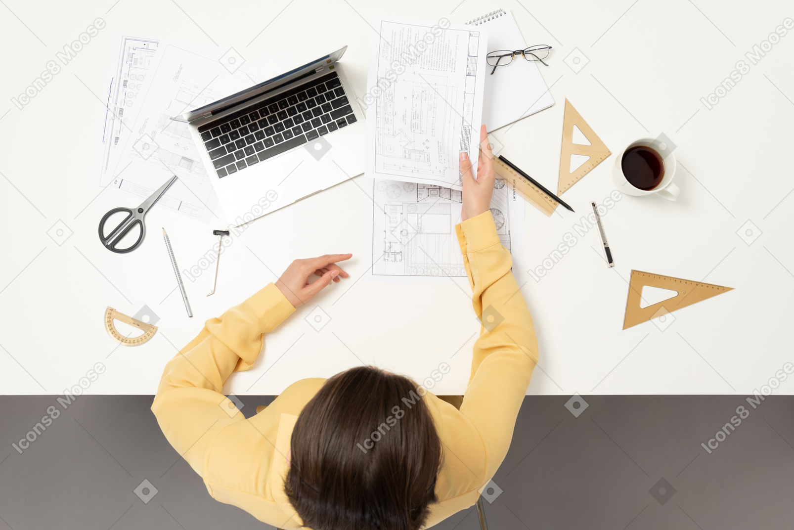 A female architect passing an architectural drawing