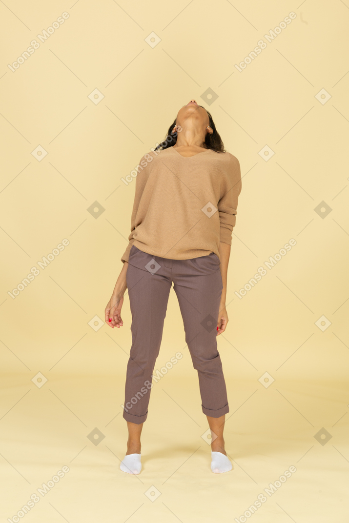 Vista frontal de una mujer joven de piel oscura cansada recostada hacia atrás