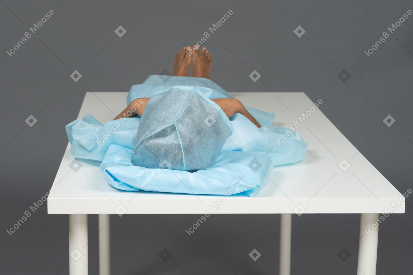 Kid lying down on the table with covered head