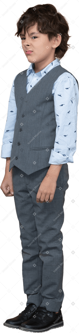 Front view of a cute boy in grey suit making faces