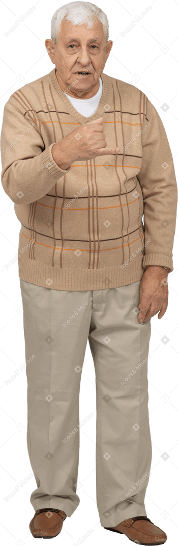 Vista frontal de un anciano con ropa informal que muestra el puño cerrado