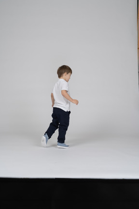 Back view of a little boy walking away