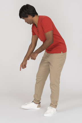 Young man bending and pointing down