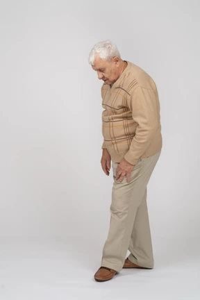 Side view of an old man in casual clothes looking down