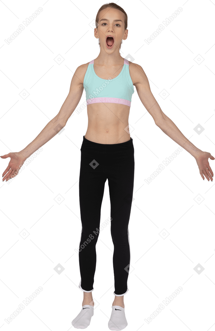 Front view of a surprised teen girl in sportswear outspreading hands and opening her mouth
