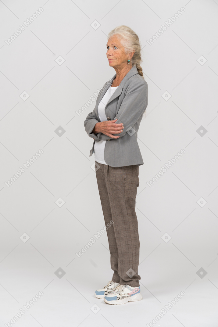 一位身穿灰色夹克、双臂交叉摆姿势的老妇人的侧视图